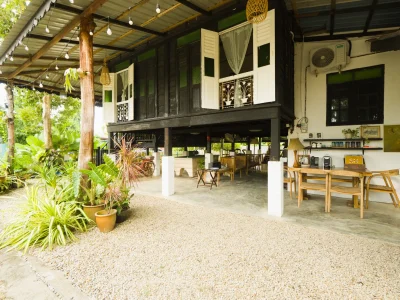 Rumah Teduh Langkawi outdoor living area with tropical garden and traditional Malay house