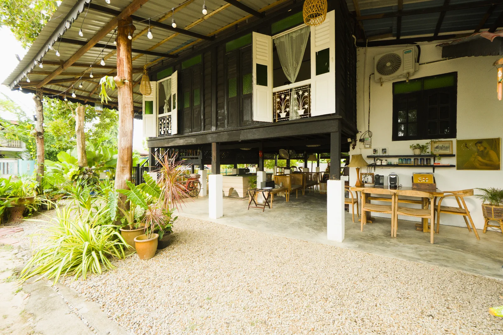 Rumah Teduh Langkawi outdoor living area with tropical garden and traditional Malay house
