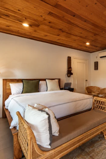 Rumah Teduh Langkawi – Wooden Bedroom Wooden bedroom with a rattan bed and warm tropical interior at Rumah Teduh Langkawi
