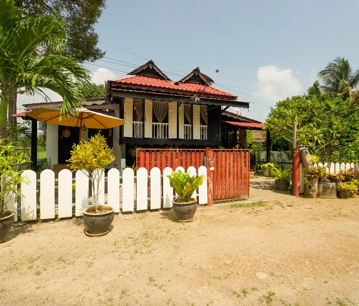 Second Home Langkawi – Rumah Teduh Lily Traditional Malay house veranda at Rumah Teduh Langkawi with rattan chairs and bamboo blinds